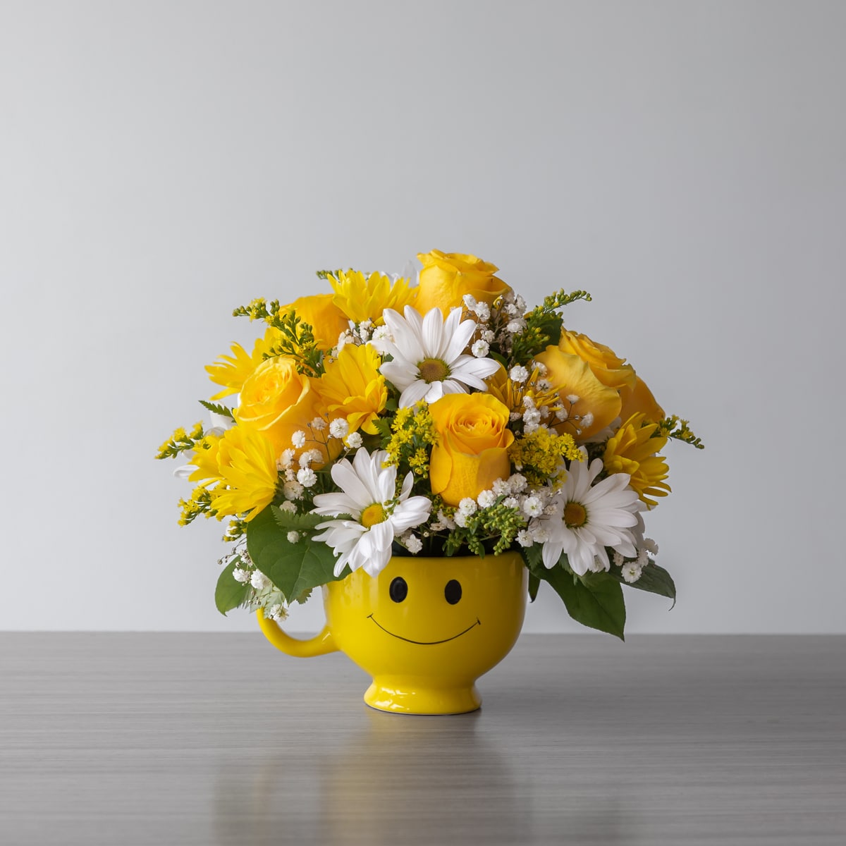 Flowers in a yellow smiley face mug