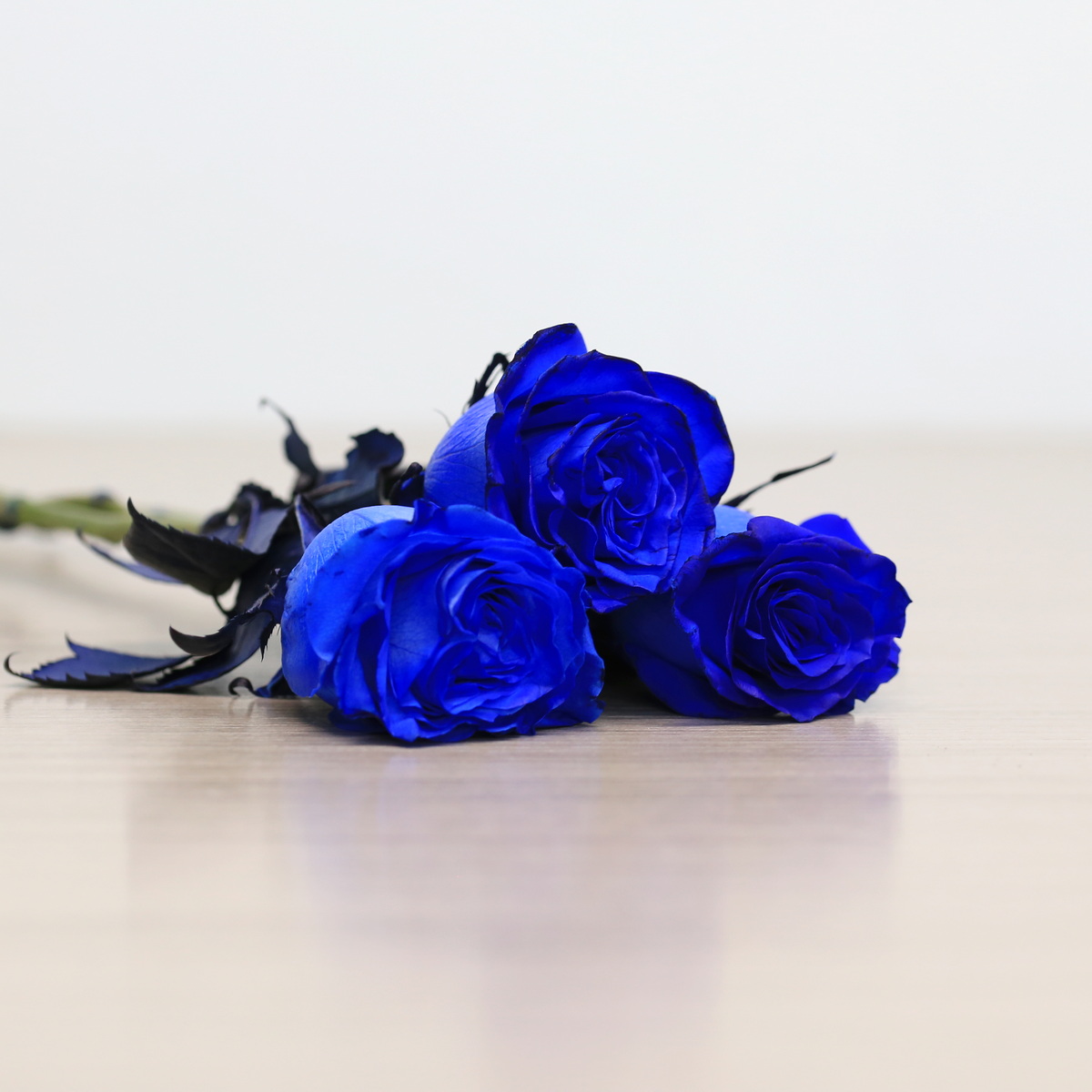 Blue roses with greenery arrangement