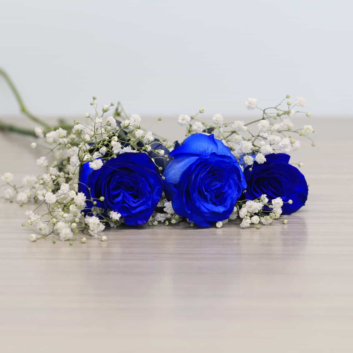 Blue roses with greenery and floral accents