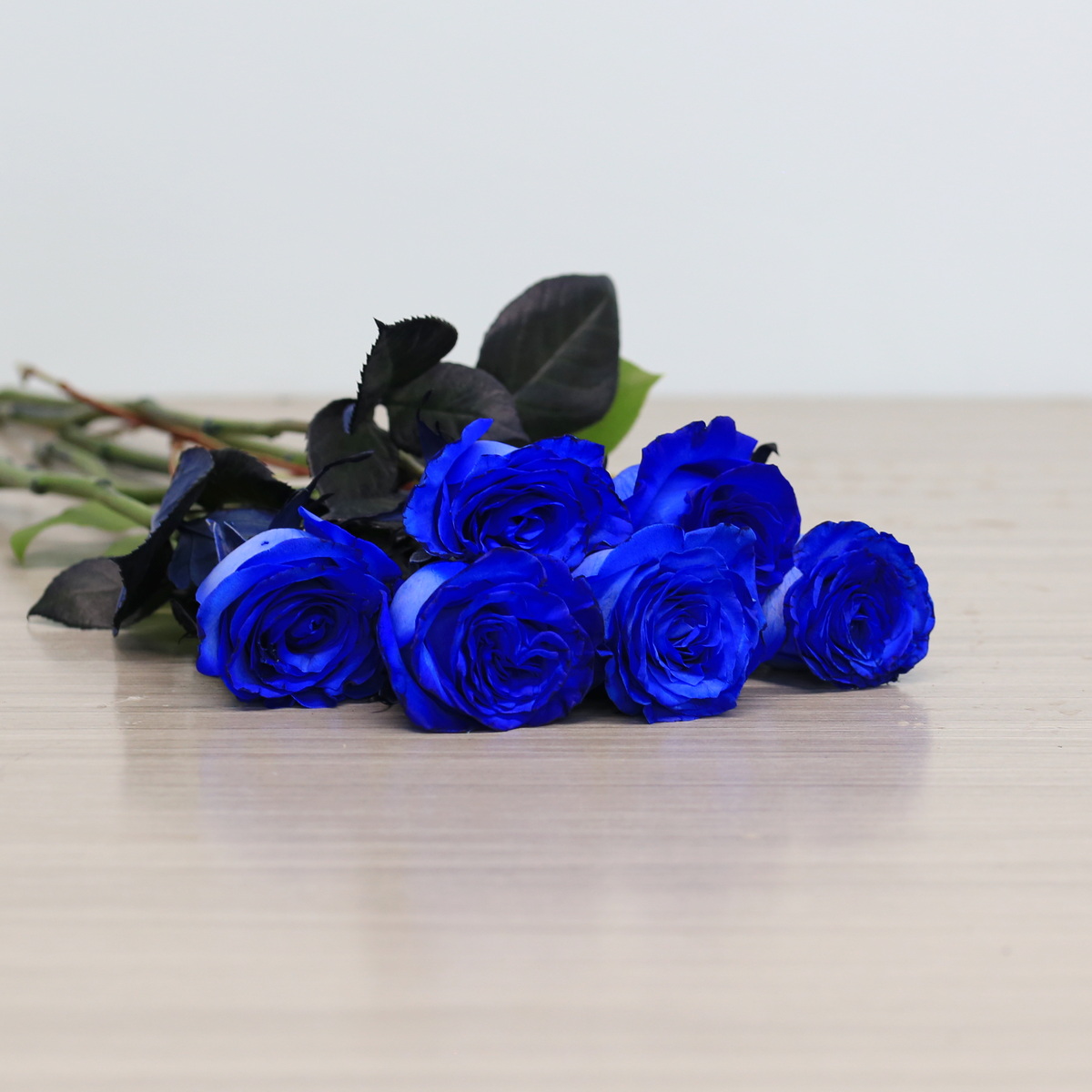 Blue roses with greenery arrangement