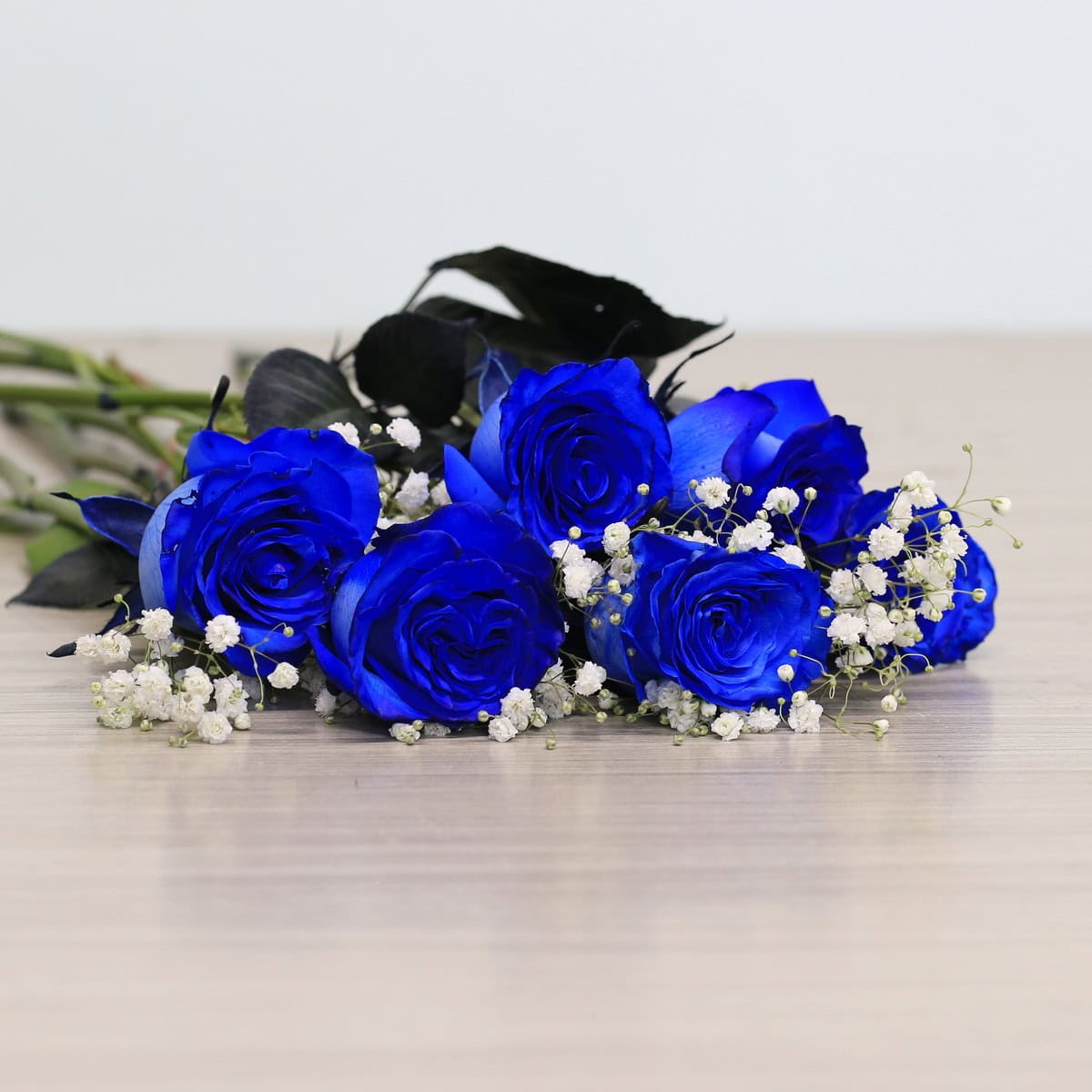 Blue roses with greenery and floral accents
