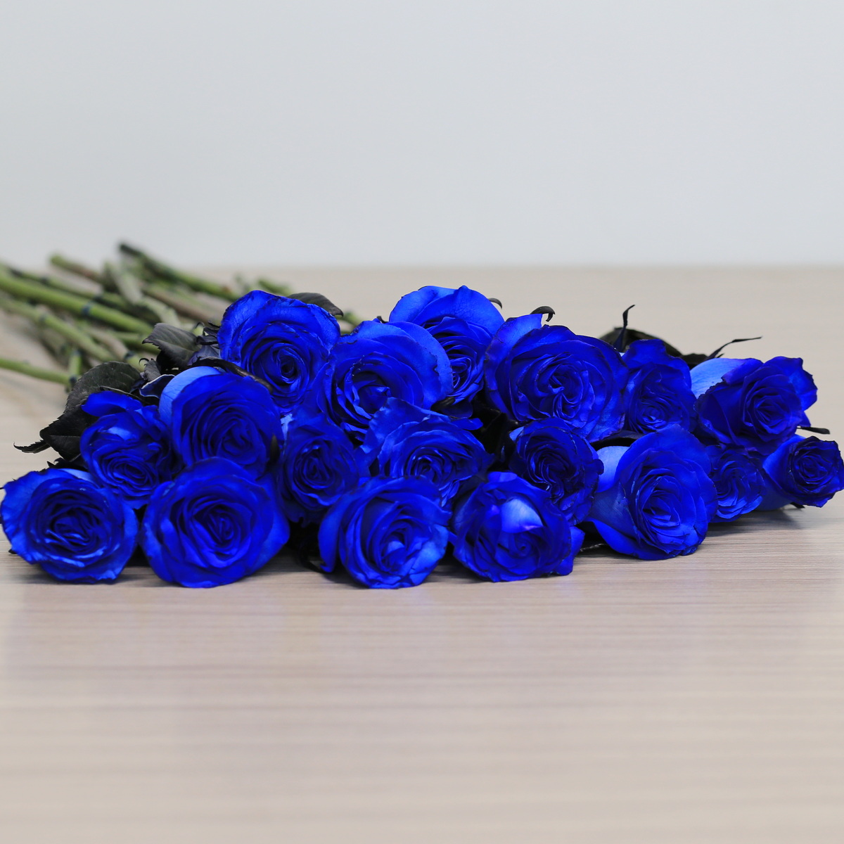 Blue roses with greenery arrangement