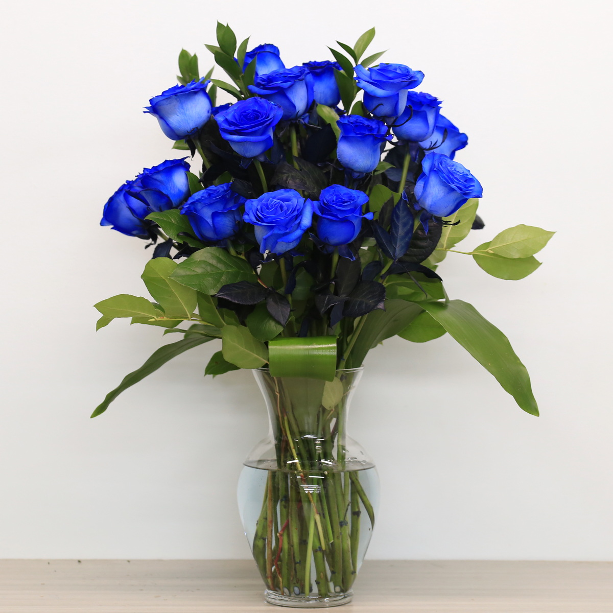 Blue roses with greenery in vase