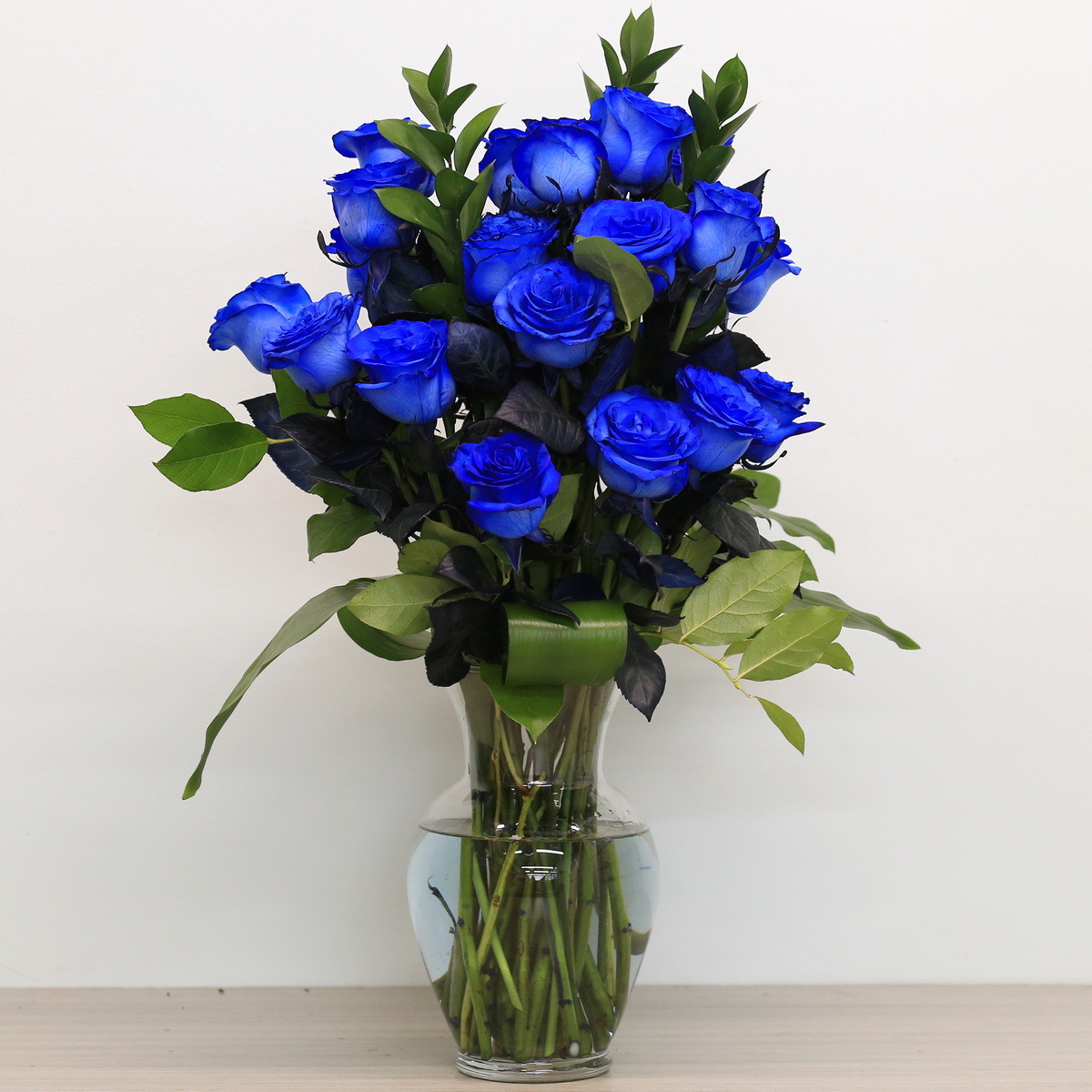 Blue roses with greenery in vase