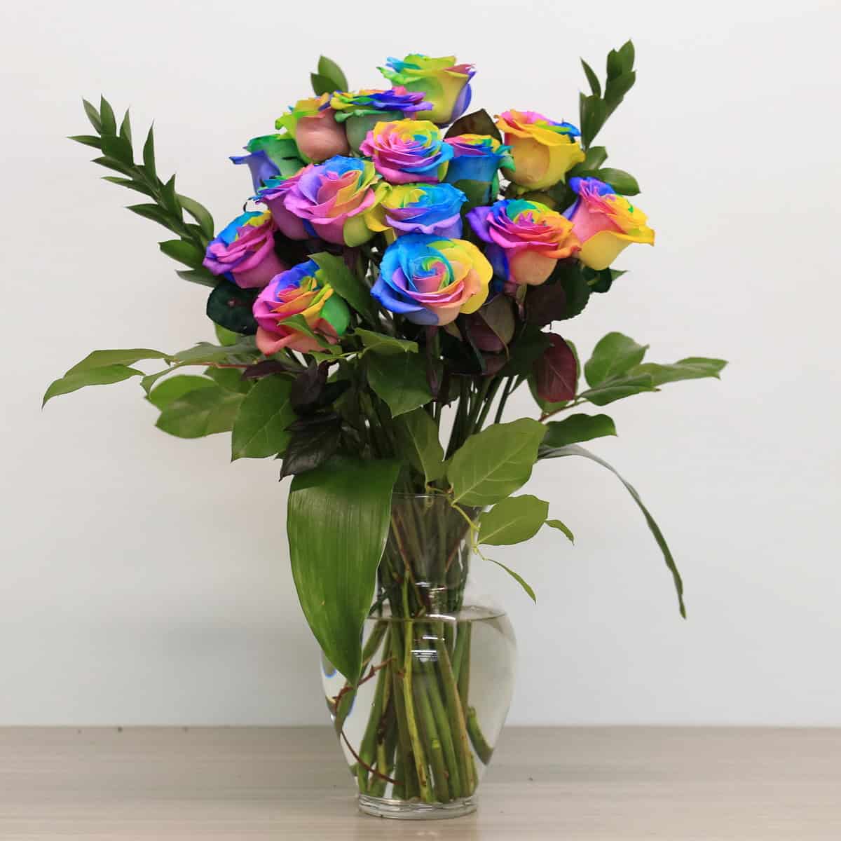 rainbow roses arranged bouquet with greenery