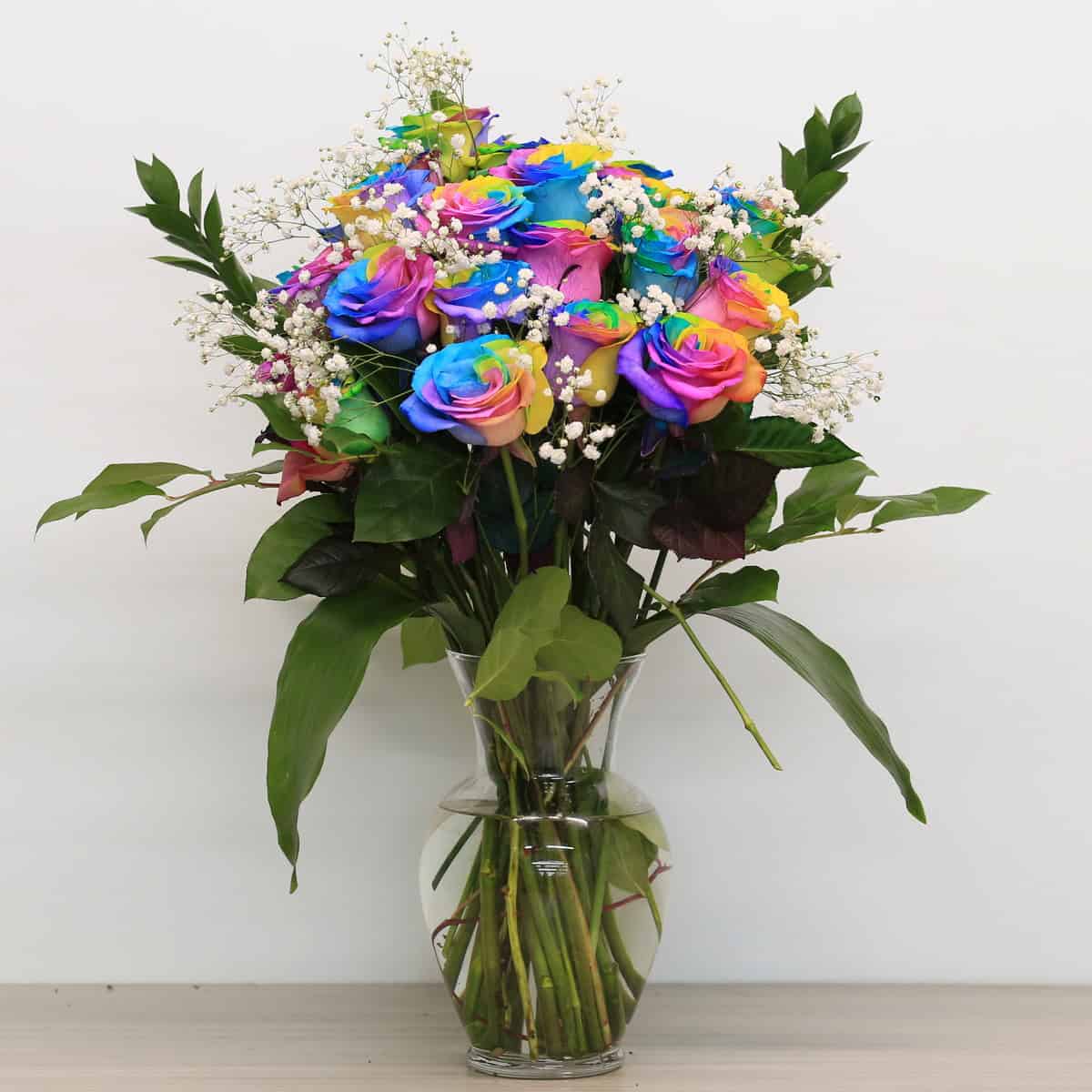 rainbow roses arranged bouquet with greenery and floral accents