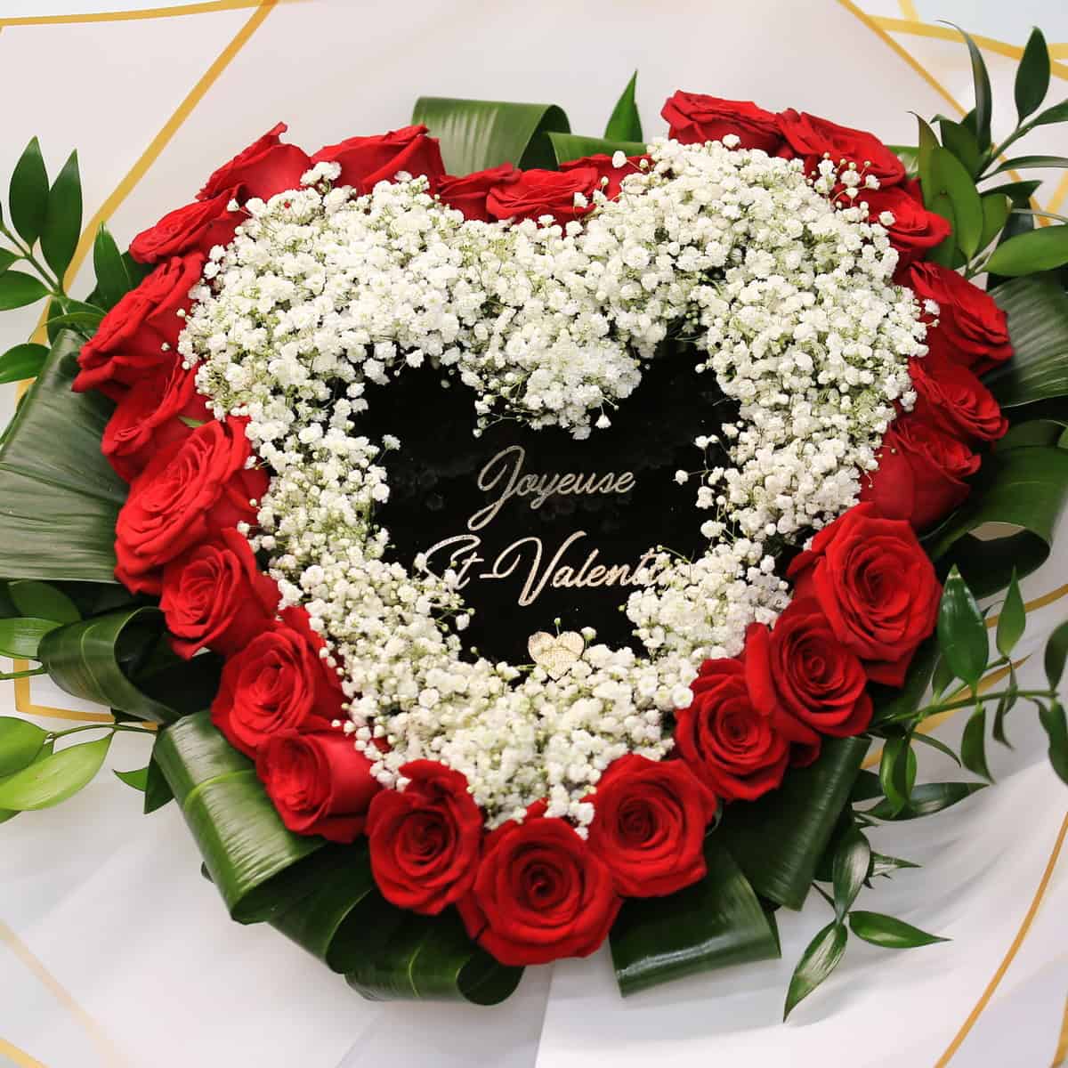 Heart-shaped bouquet of 24 red roses with baby’s breath and a personalized message in the center.