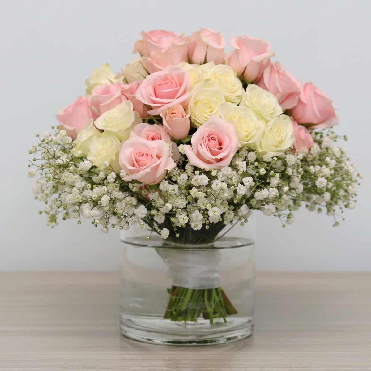 Soft Romance arrangement with pink and white spray roses and baby's breath in glass vase