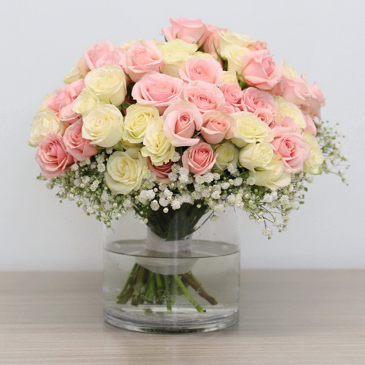 Soft Romance arrangement with pink and white spray roses and baby's breath in glass vase